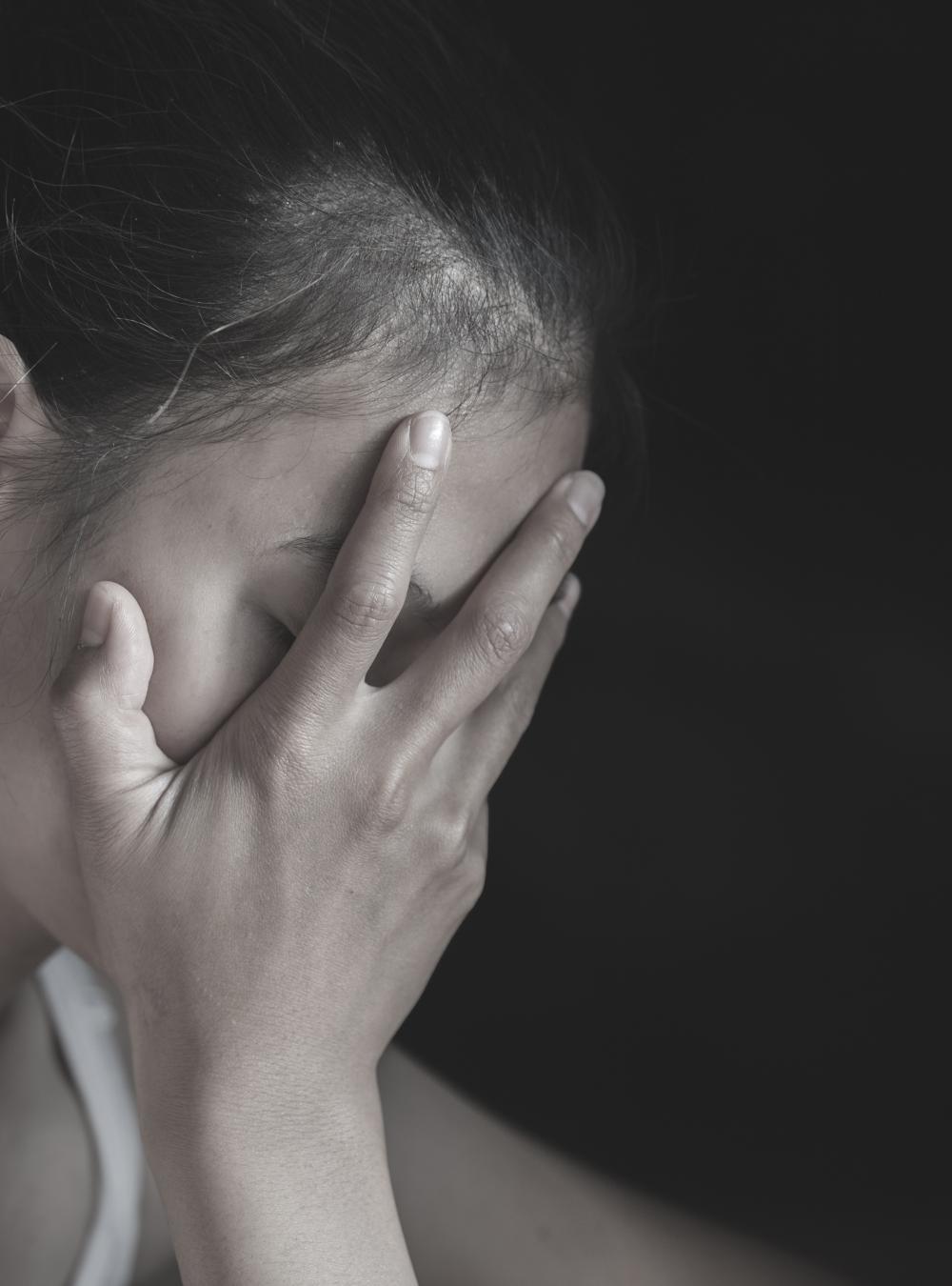 Young woman covering her face