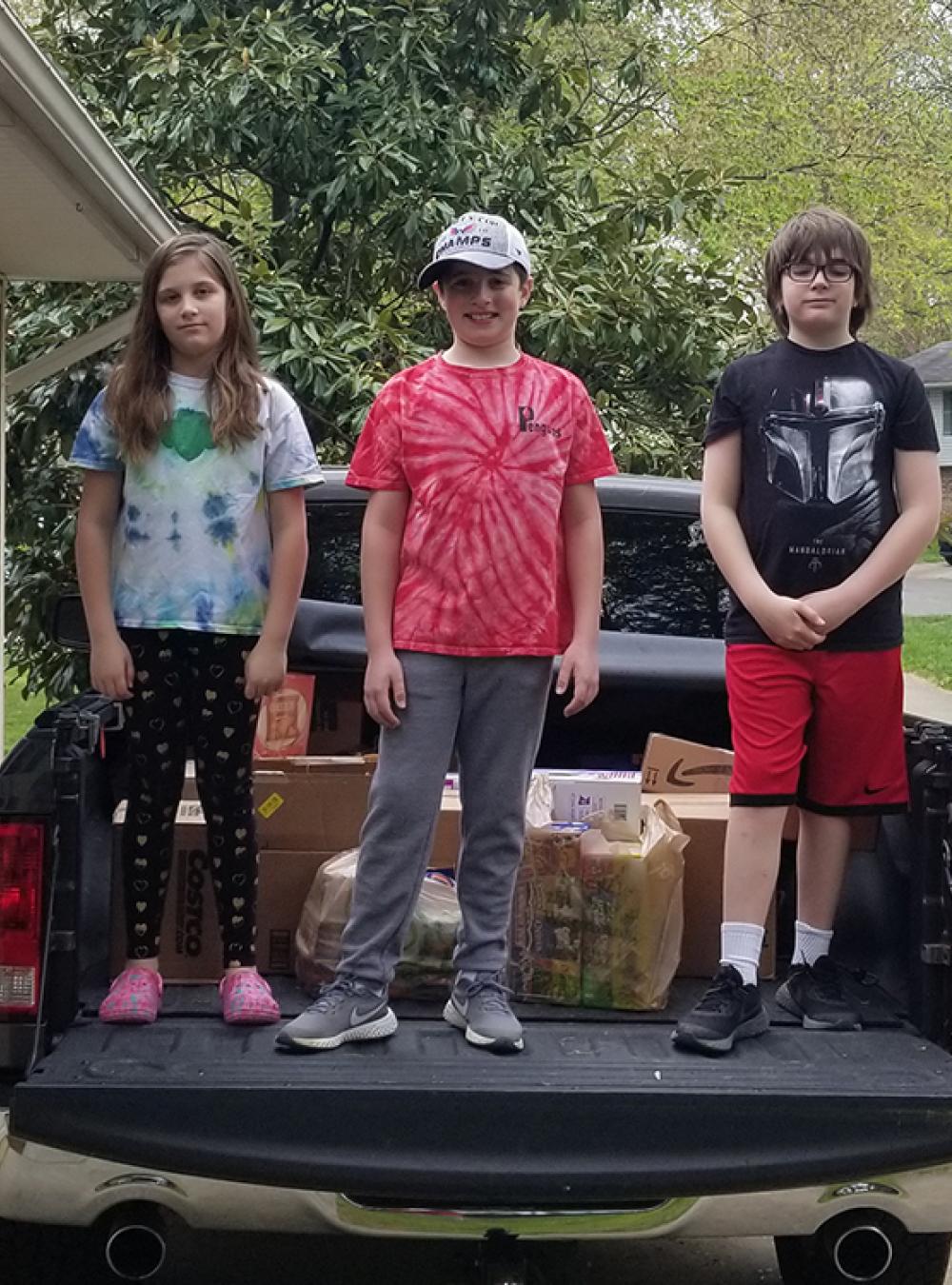 Rob Irvine’s kids loading up his truck with MITRE employees’ donations for the food bank