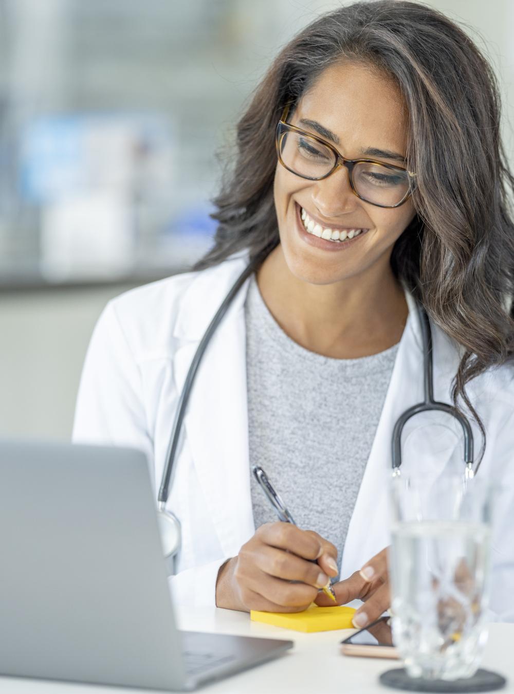 Doctor connecting with a patient virtually and taking notes