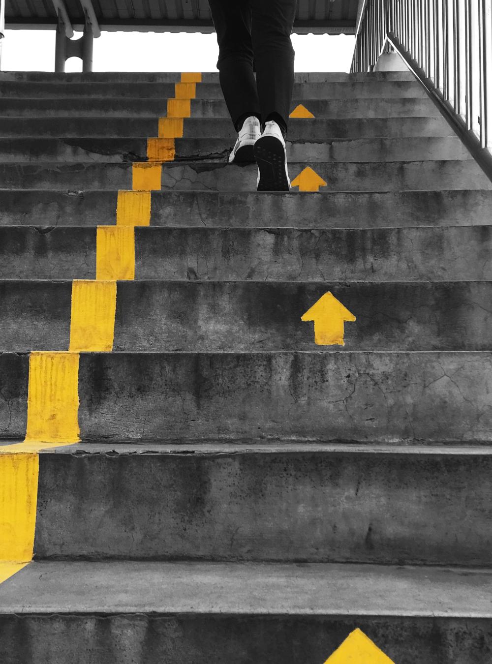 Runner going upstairs guided by arrows on the steps