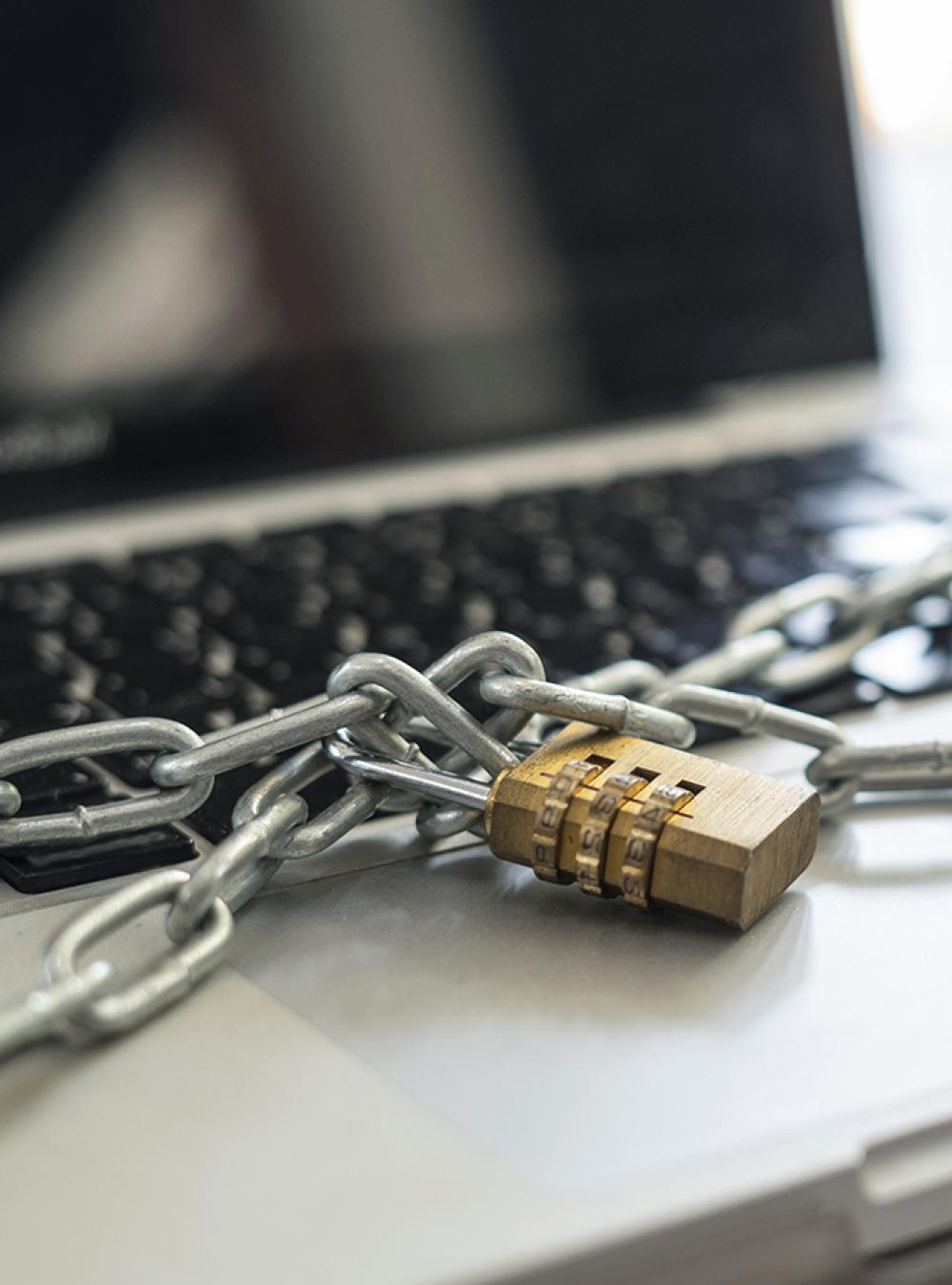 Laptop with locked chains securely wrapped around the keyboard