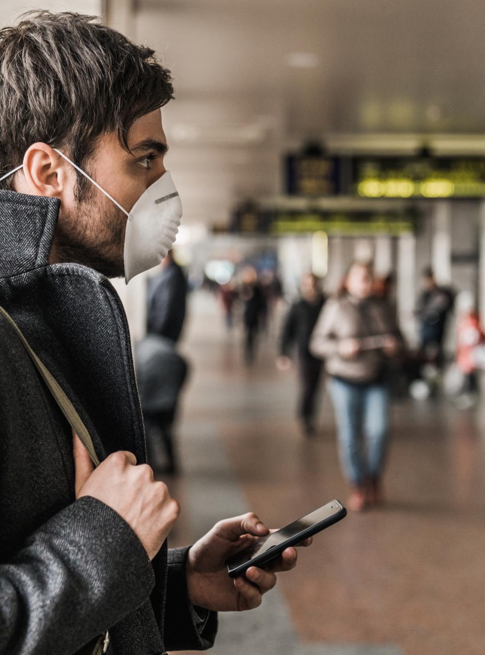 Man in mask and socially distancing while at an airport