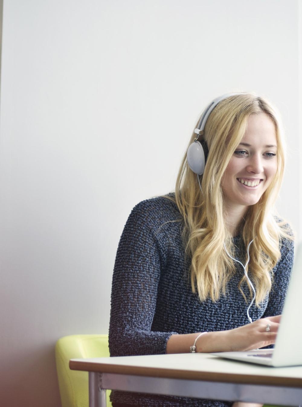 Woman wearing headphones at a desk