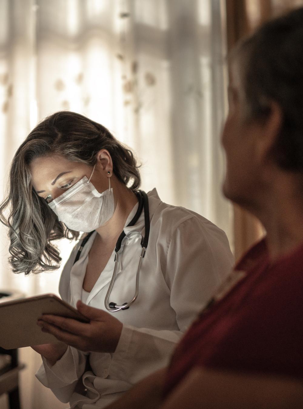 Doctor treating a nursing home resident in her living space