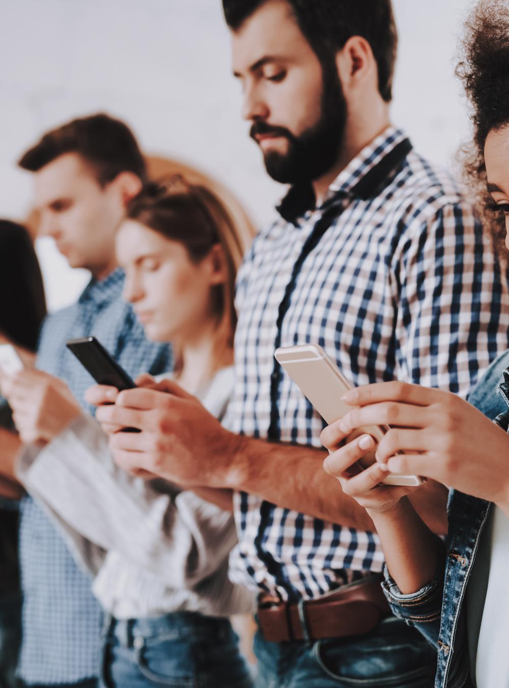 Lineup of people all absorbed in their smartphones