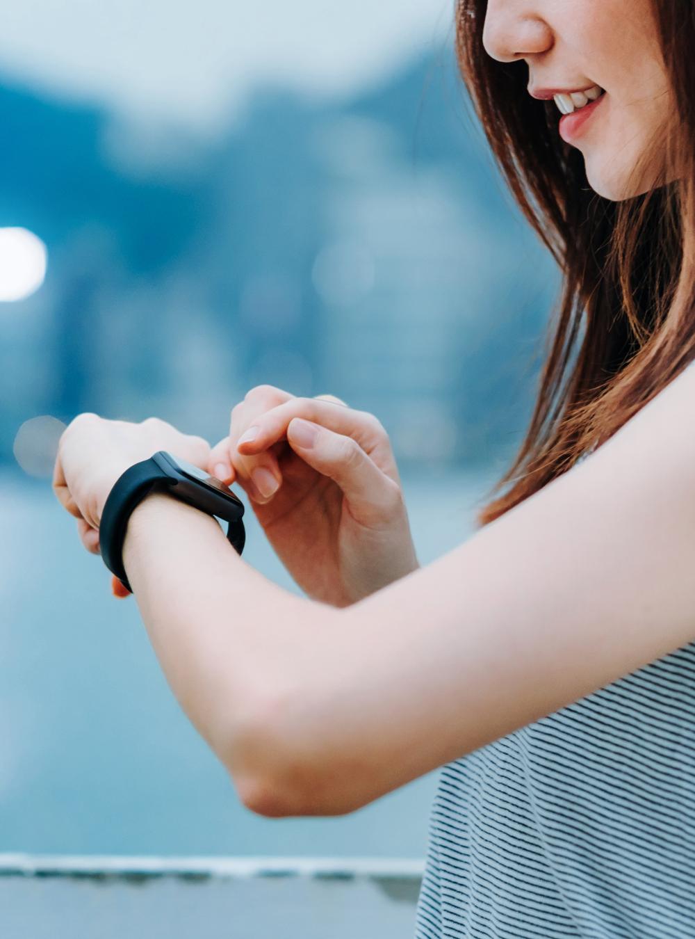 Runner checking her health data on a smart watch