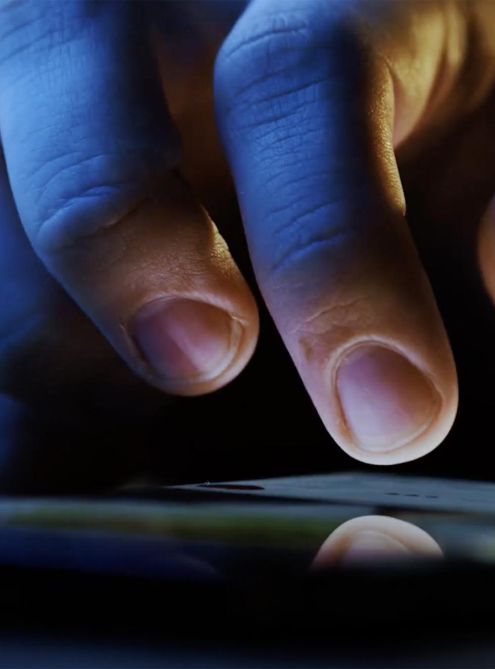 Persons finger touching phone screen