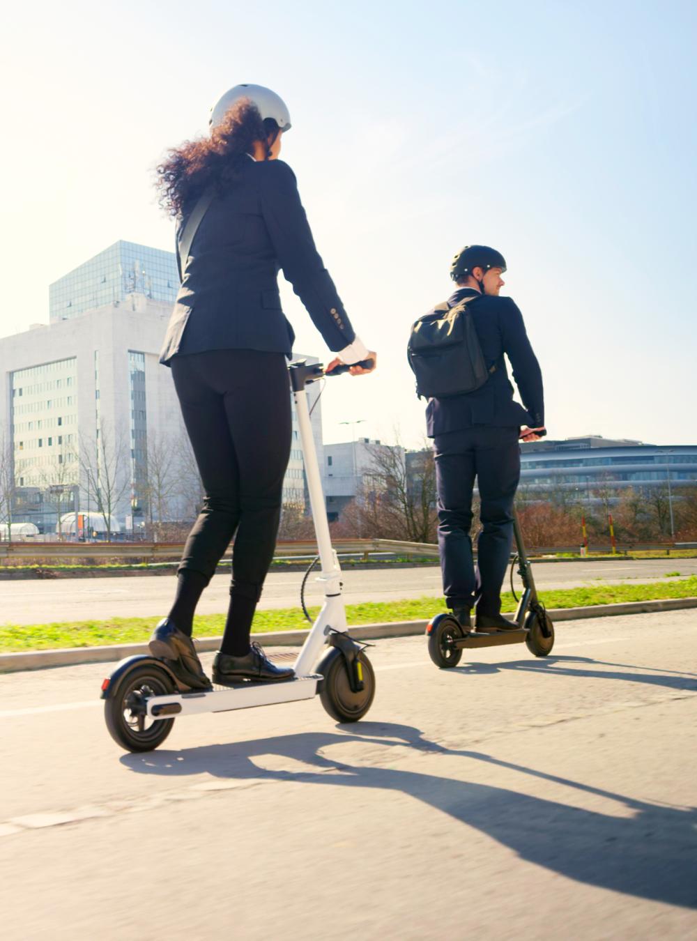 Business people riding electric push scooter in city