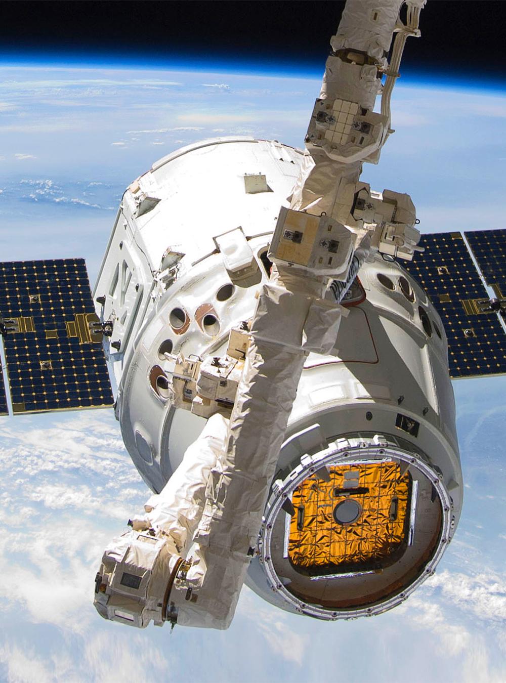 The SpaceX Dragon cargo craft is attached to the Candarm2 while in Space