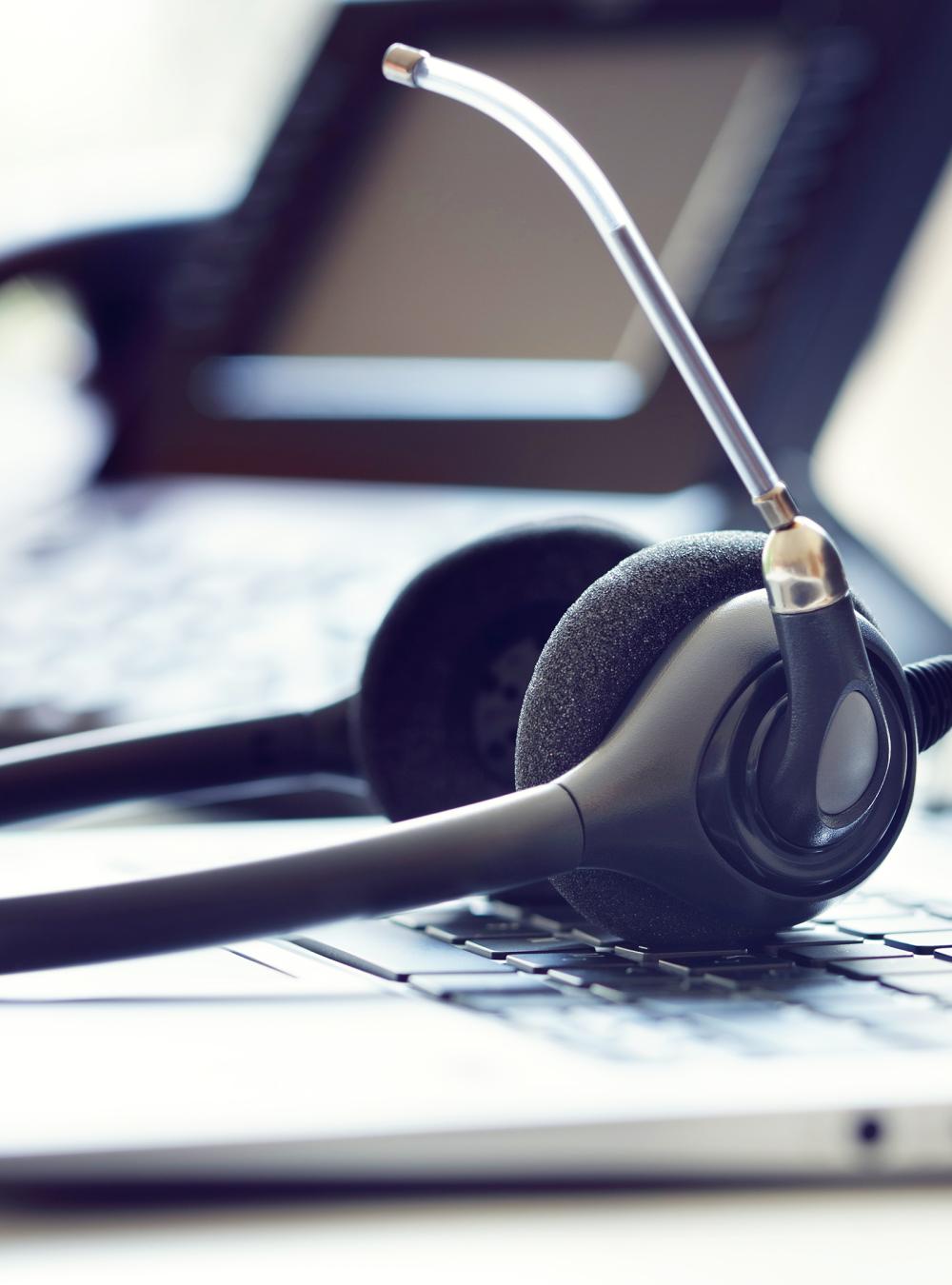 headset, telephone, and laptop on a desk