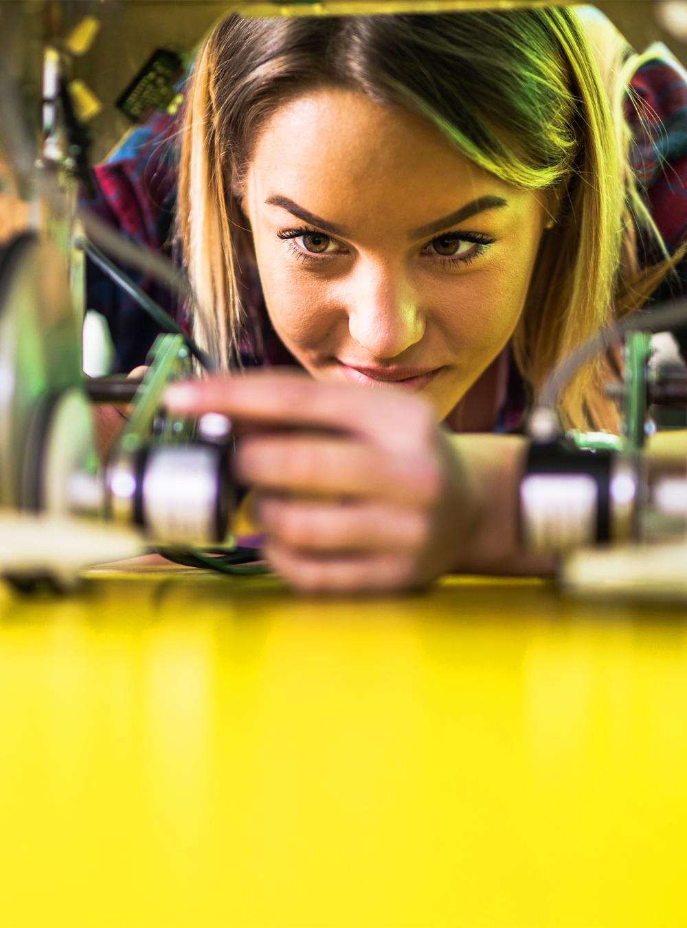 Woman examining robotic parts