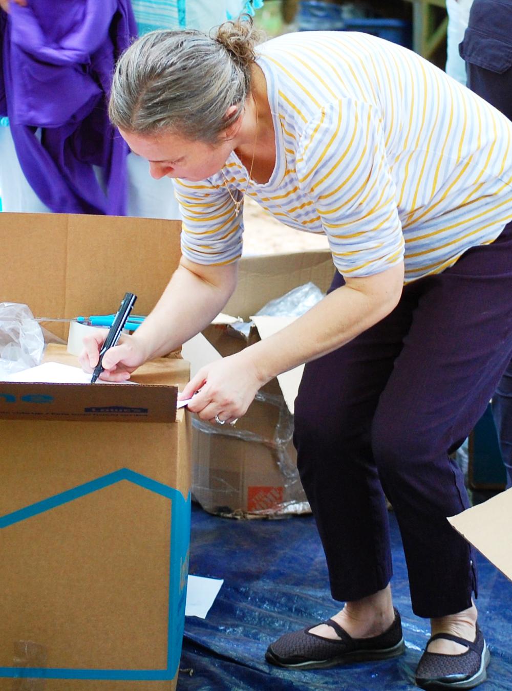 Tanya Wynn writing on a cardboard box