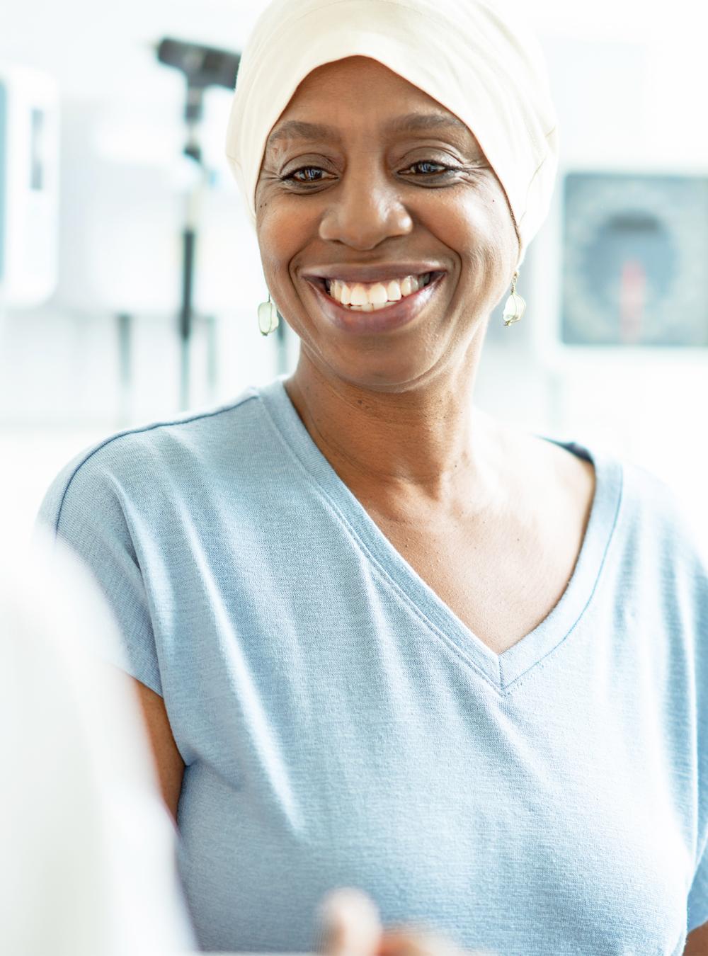 A senior woman wearing a head scarf is seen by her doctor