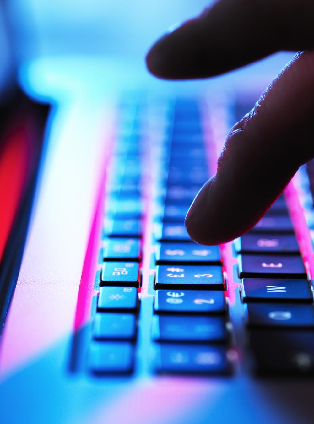 Close-up photo of someone typing on a keyboard