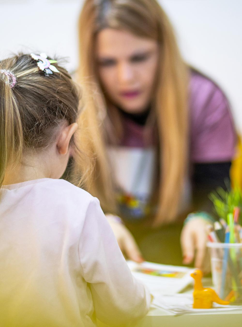 Teacher and child talking in a daycare setting