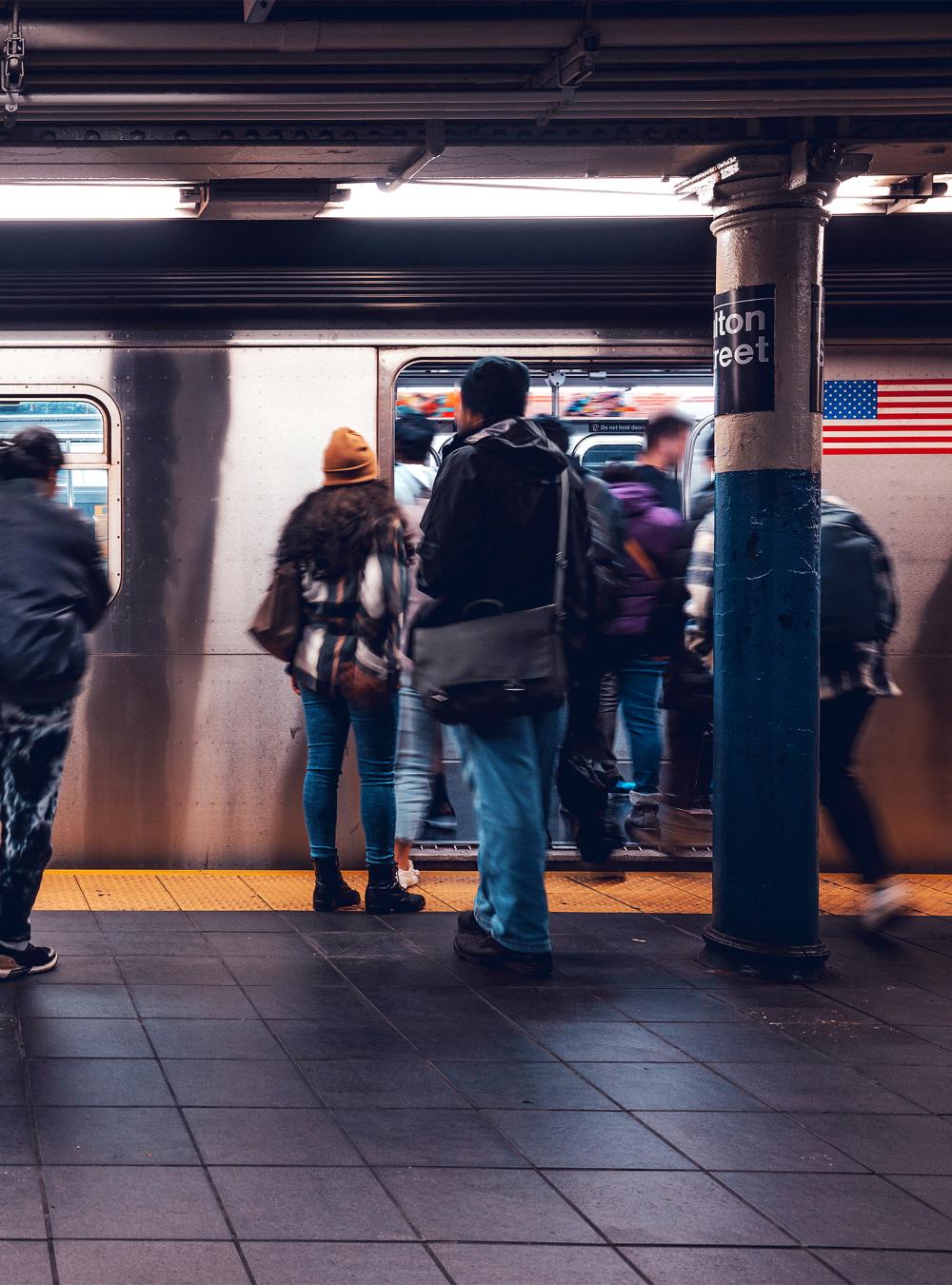 Crowd of people in a NYC subway station waiting for the train