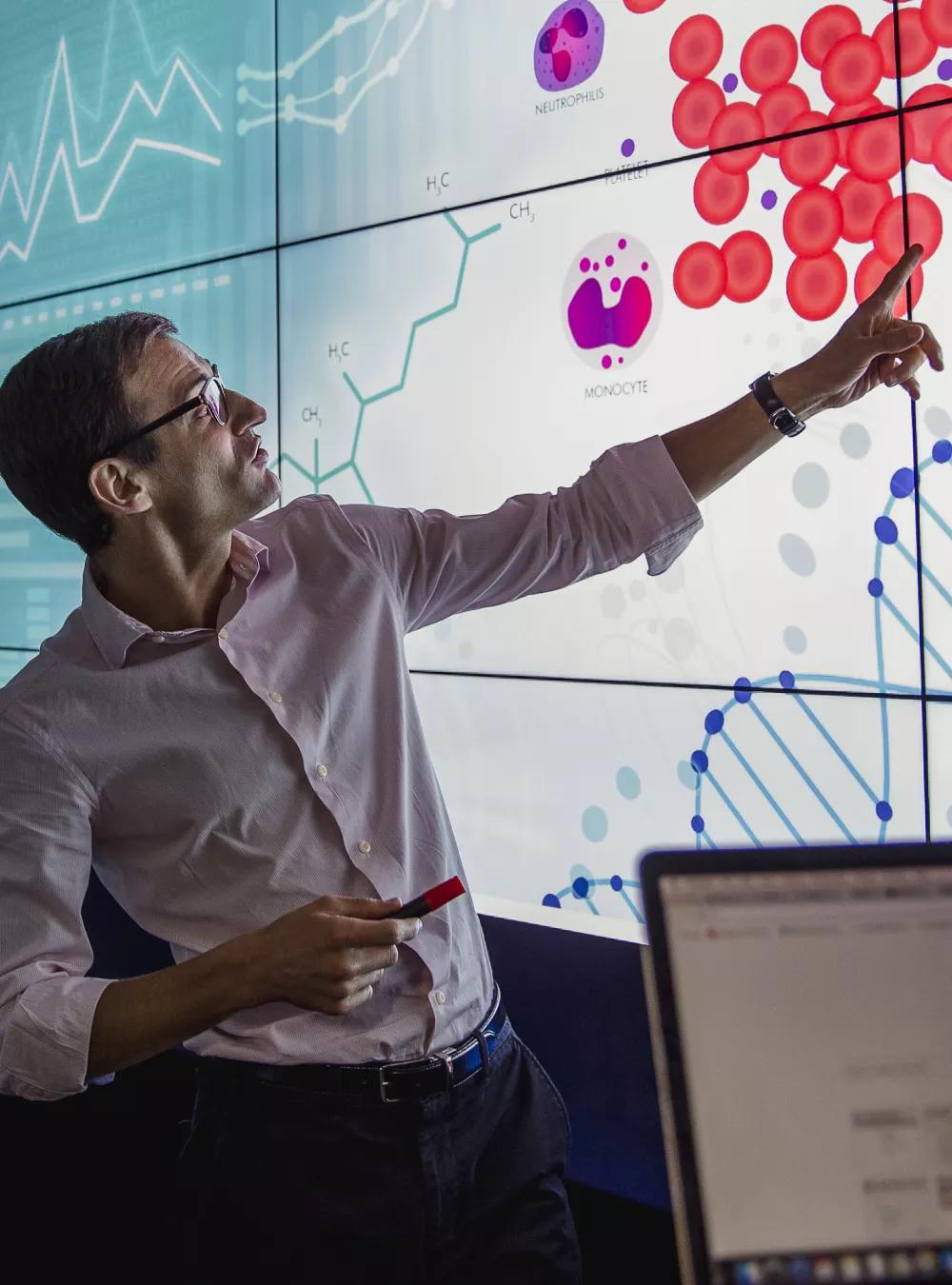 Group of professionals reviewing health data on a large screen