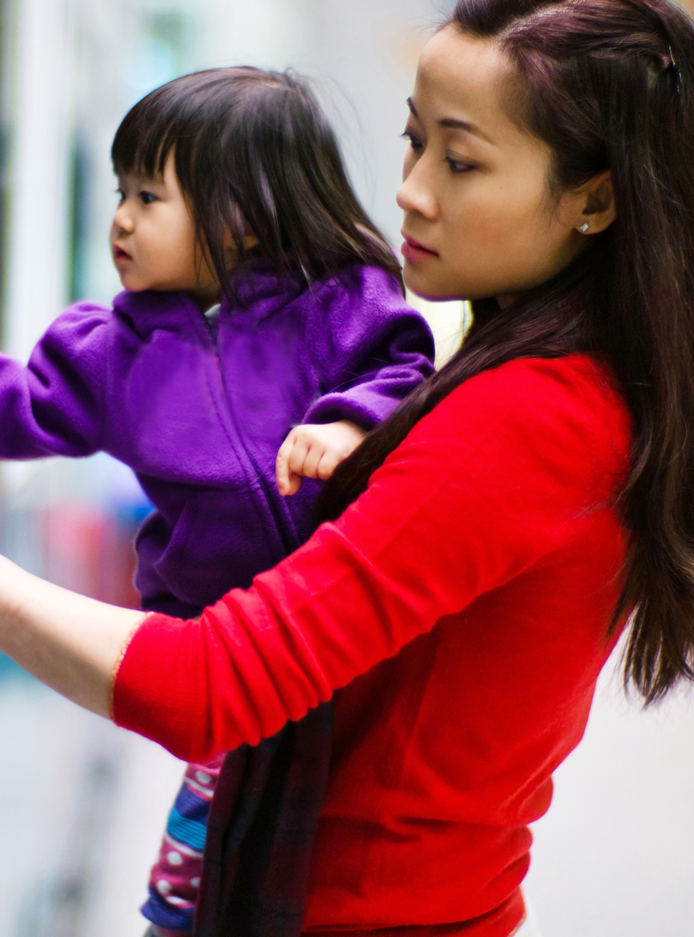 Mother and daughter using a banking machine outside