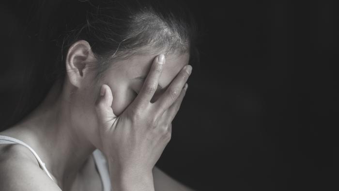 Young woman covering her face