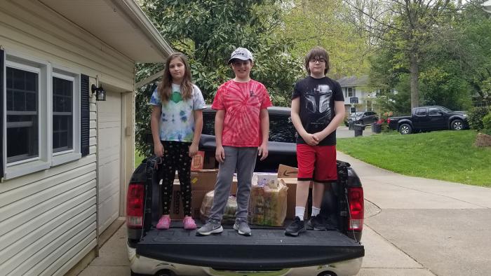 Rob Irvine’s kids loading up his truck with MITRE employees’ donations for the food bank