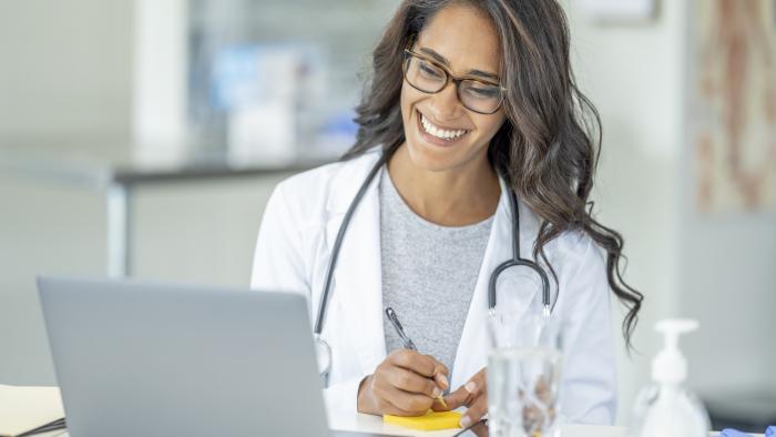 Doctor connecting with a patient virtually and taking notes