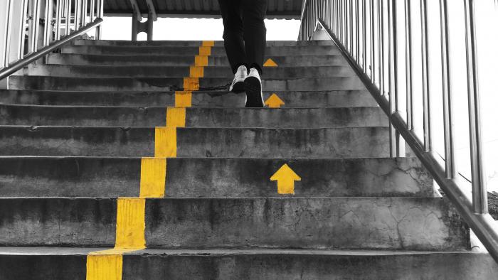 Runner going upstairs guided by arrows on the steps