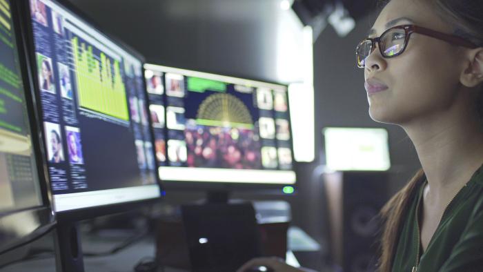 Woman monitoring multiple screens