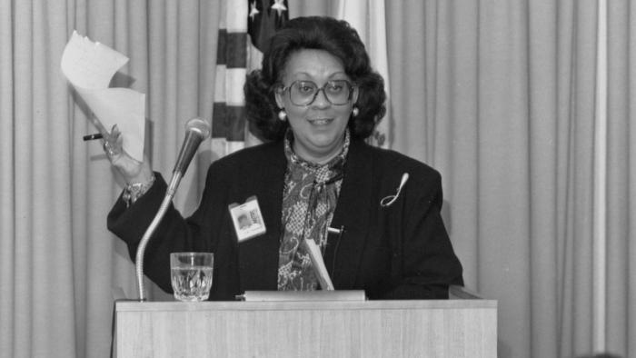 Black and white image of Lydia Thomas speaking at a podium