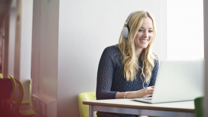 Woman wearing headphones at a desk