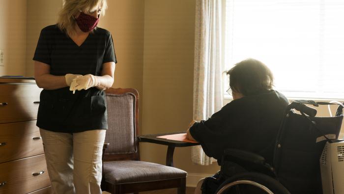 Provider assisting a resident at a nursing home who is in a wheelchair