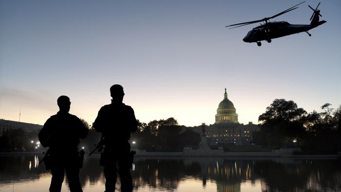 Security team with U.S. Capitol in in the background and helicopter flying by