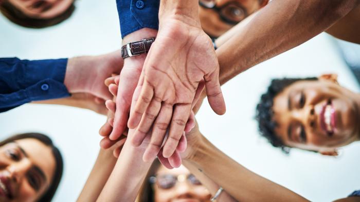 People coming together in a circle, stacking hands