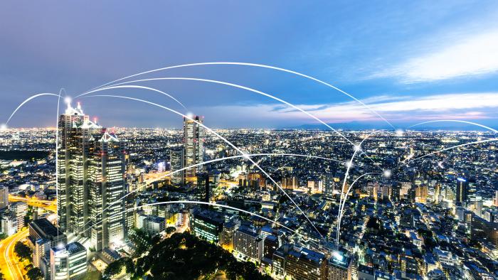 City scene with streams of light showing the data that connects us