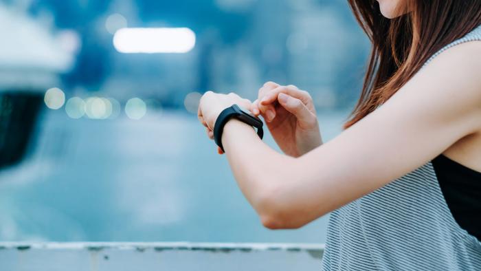 Runner checking her health data on a smart watch