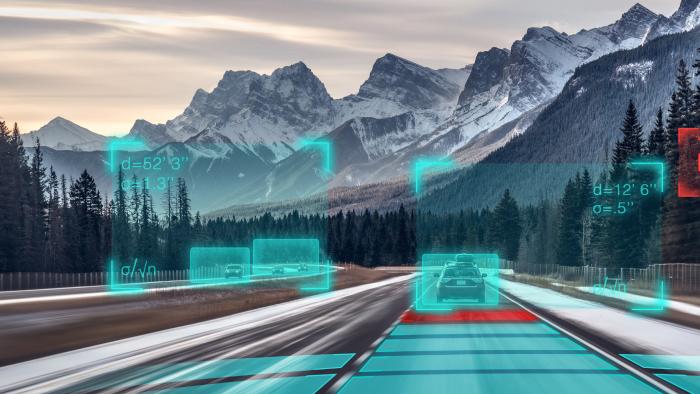 Automated vehicles driving on a road near a snowy mountain range