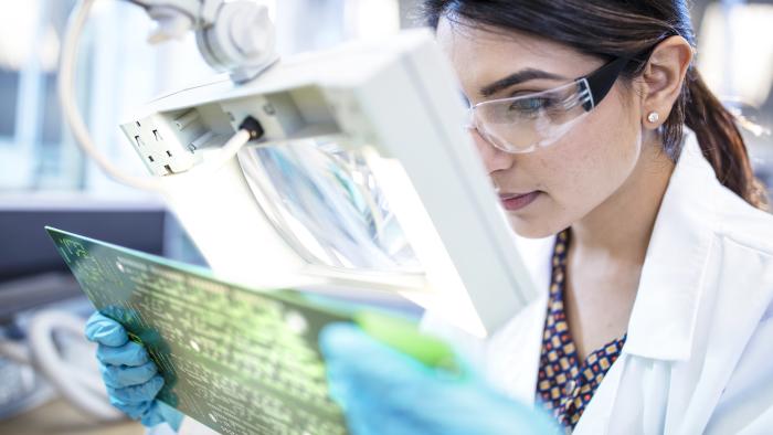 female inspecting circuit board