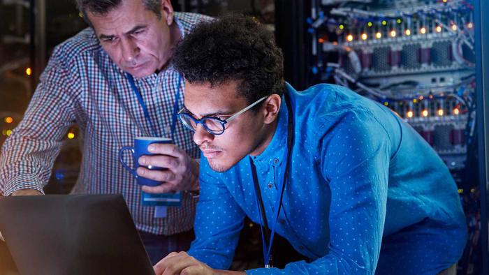 Two men looking at a laptop