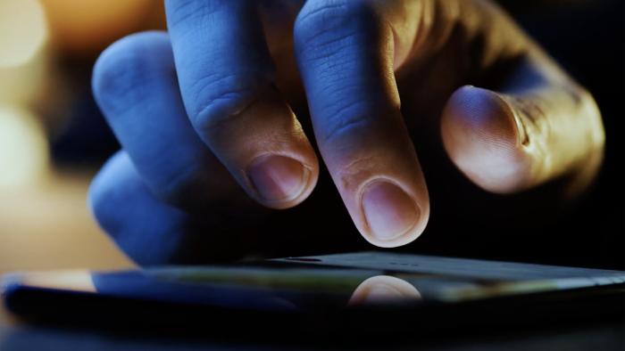 Persons finger touching phone screen