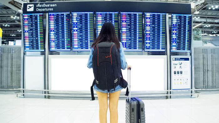 girl in front of a departure board