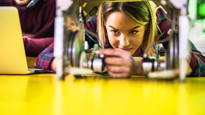 Woman examining robotic parts