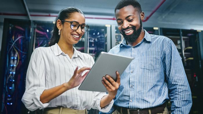 Two colleagues working together on a tablet