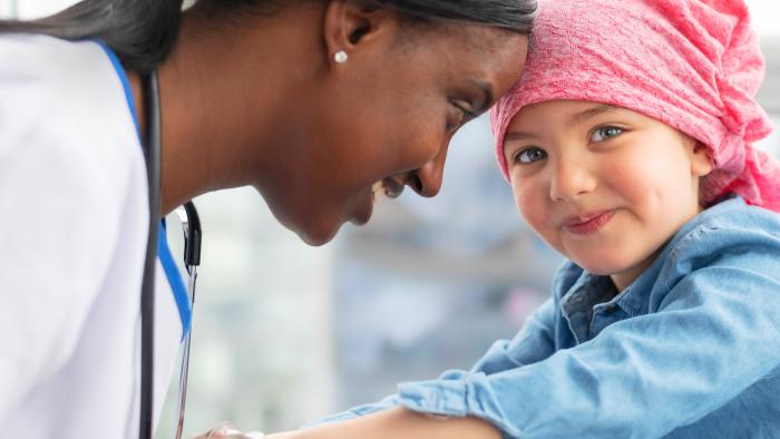 Female doctor comforts her young patient who has cancer