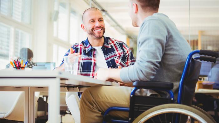 Handicap businessman sitting with colleague in the office