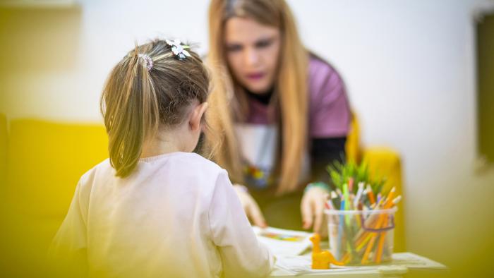 Teacher and child talking in a daycare setting