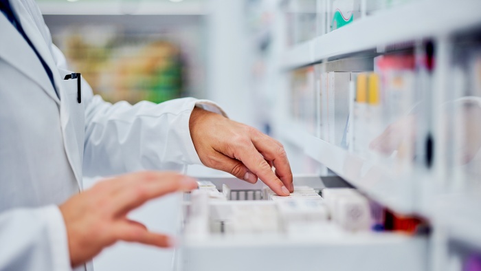 Side view of a pharmacist reaching in a drawer