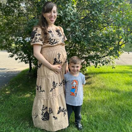 A photo of Jessica Dooley and her son standing outside in front of a tree