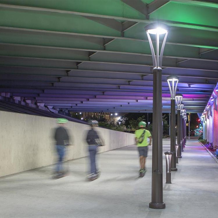 People on e-scooters on a lit pathway